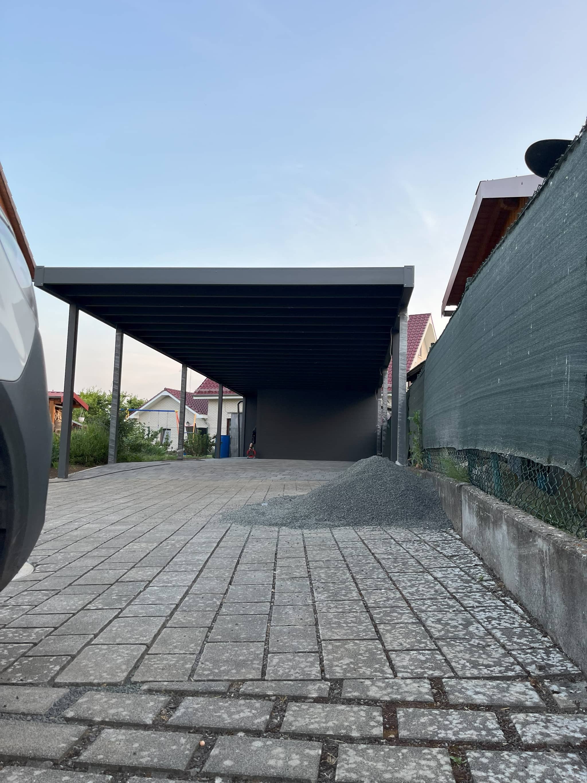 Flachdach-Carport aus Aluminium in Anthrazit mit Geräteschuppen am Ende des Stellplatzes