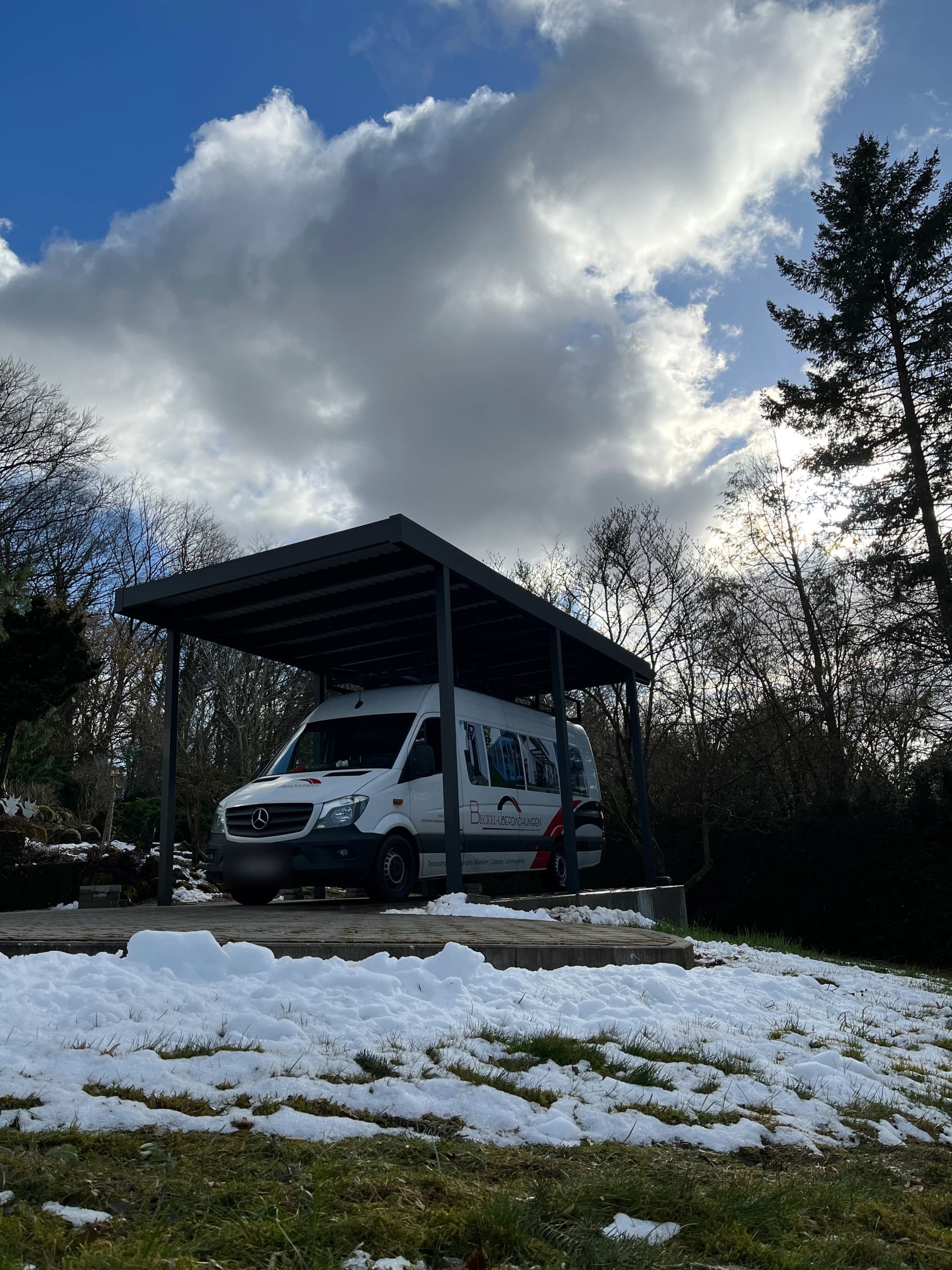 Carport aus Aluminium mit anthrazitfarbenem Flachdach, offene Konstruktion mit Stellplatz für einen Transporter